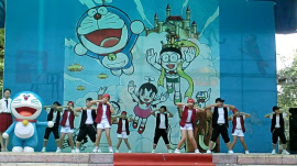 ベトナムでの出版20周年記念イベントのステージで、ドラえもんの主題歌を日本語で歌い、踊る子どもたち